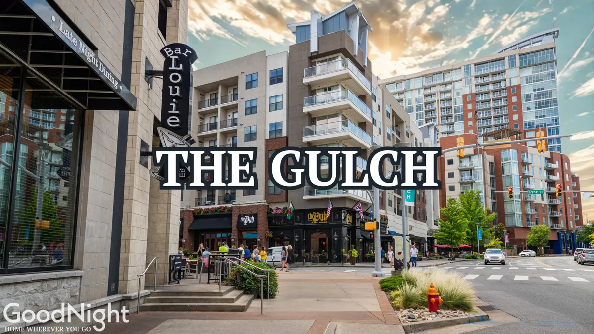 An inviting exterior scene with Bar Louie signage, modern apartment buildings, green landscaping, and active pedestrian life. The environment feels vibrant and conveniently located near dining and social options, suggesting a lively neighborhood waiting to be explored after work hours.
